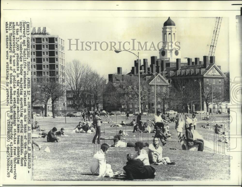 1969 Press Photo Harvard and Radcliffe students relax on bank of Charles River.