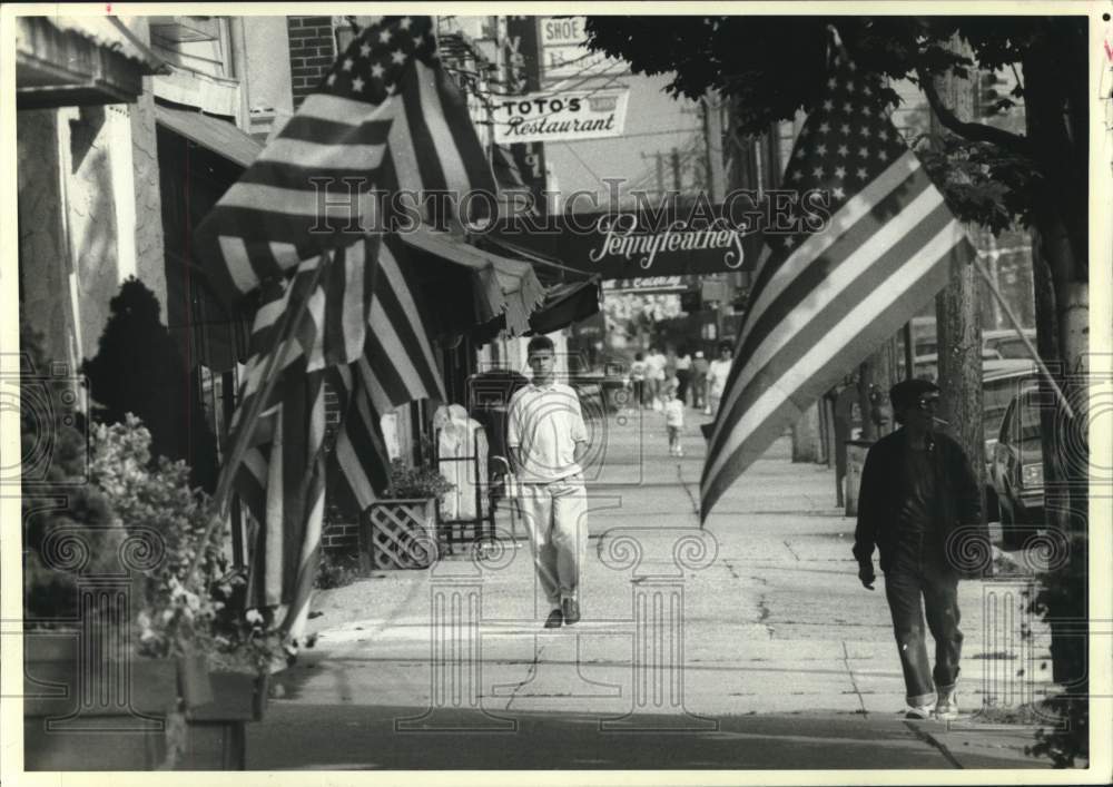1988 Press Photo American flags displayed on city street - now11360
