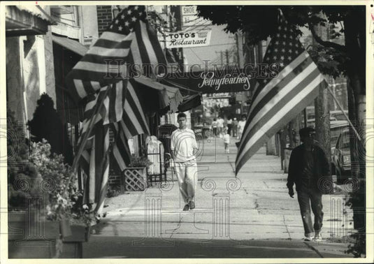 1988 Press Photo American flags displayed on city street - now11360