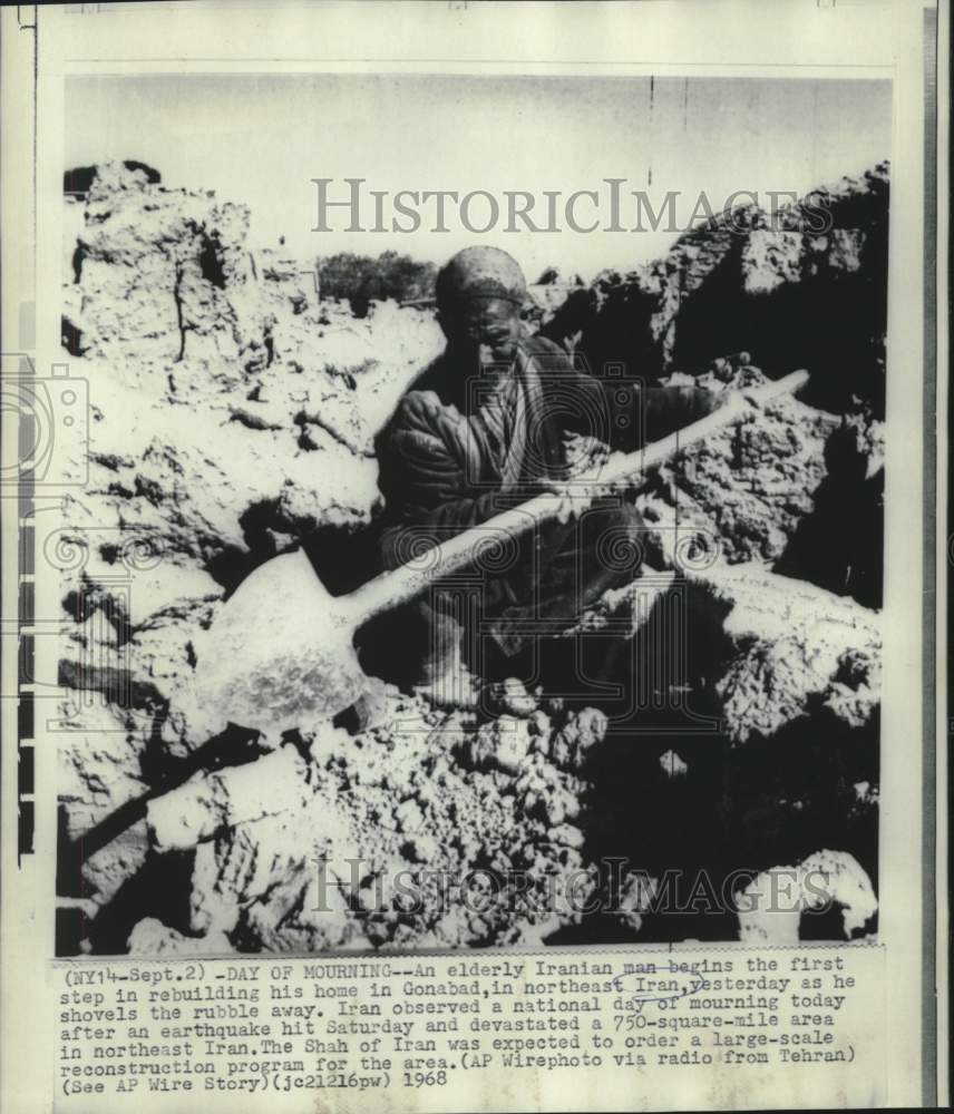 1968 Press Photo Elderly Iranian man shovels rubble from earthquake destruction
