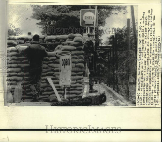 1974 Press Photo Soldier stands guard as others build sandbag fortification