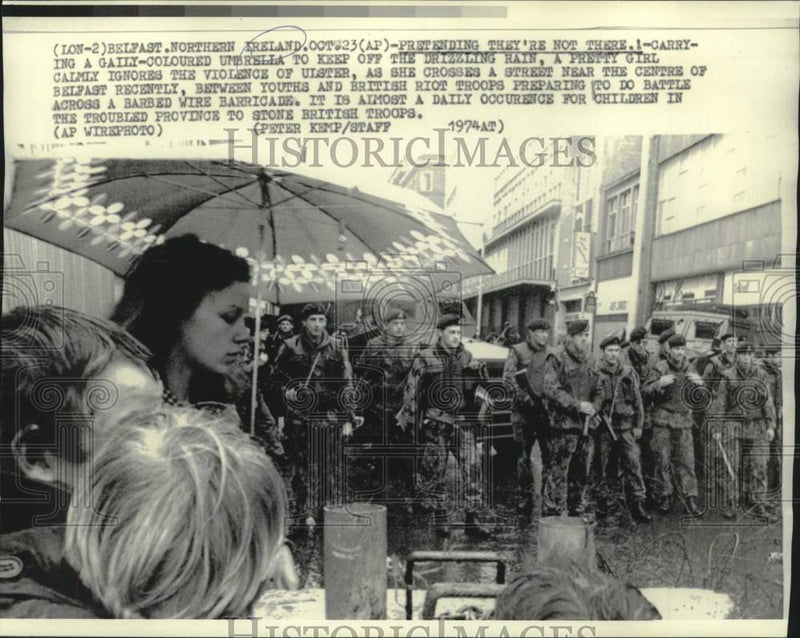 Load image into Gallery viewer, 1974 Press Photo Belfast young people ignore the violence as they cross street.
