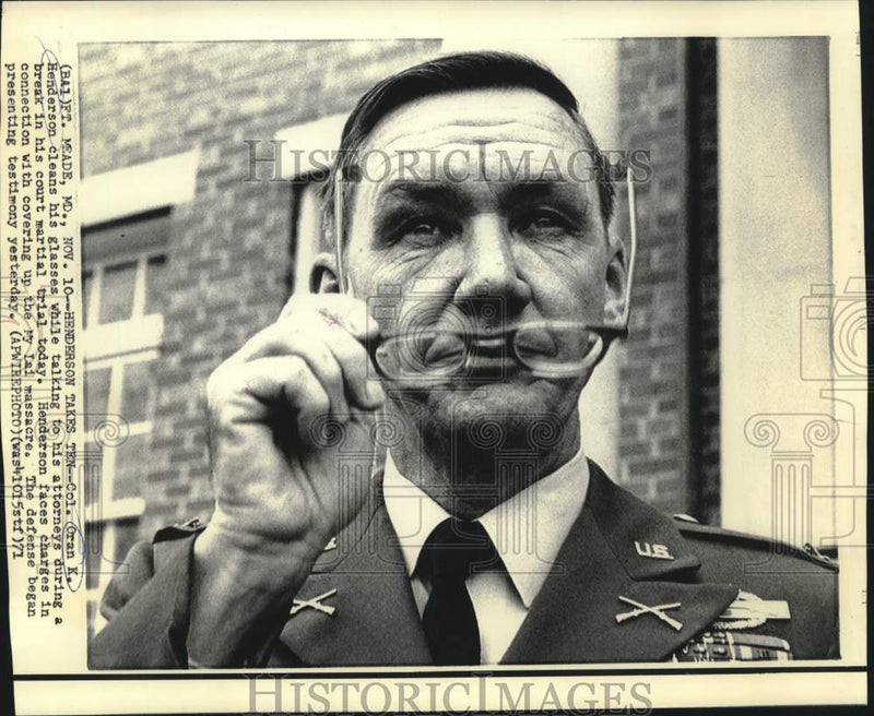 Load image into Gallery viewer, 1971 Press Photo Colonel Oran Henderson cleans glasses while talking to attorney
