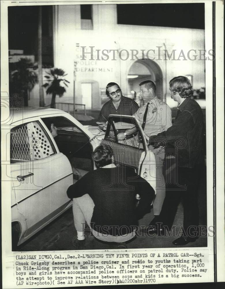 Load image into Gallery viewer, 1970 Press Photo Sgt. Chuck Grisby describes patrol car to Ride-Along youths
