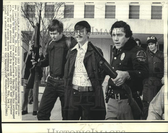 1976 Press Photo Shotgun-toting police escort Jeffery Lee from office building