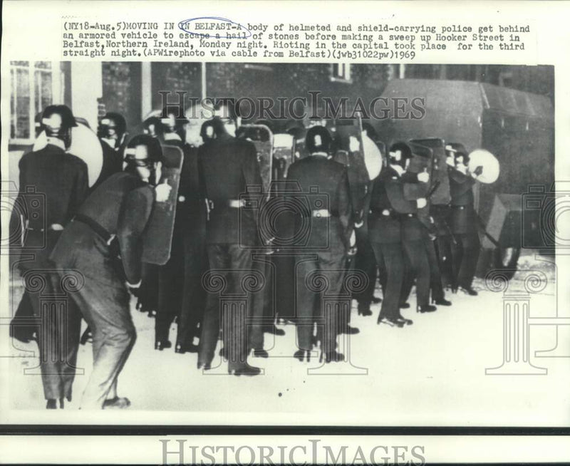 Load image into Gallery viewer, 1969 Press Photo Helmeted and shielded police behind armored vehicle in Belfast
