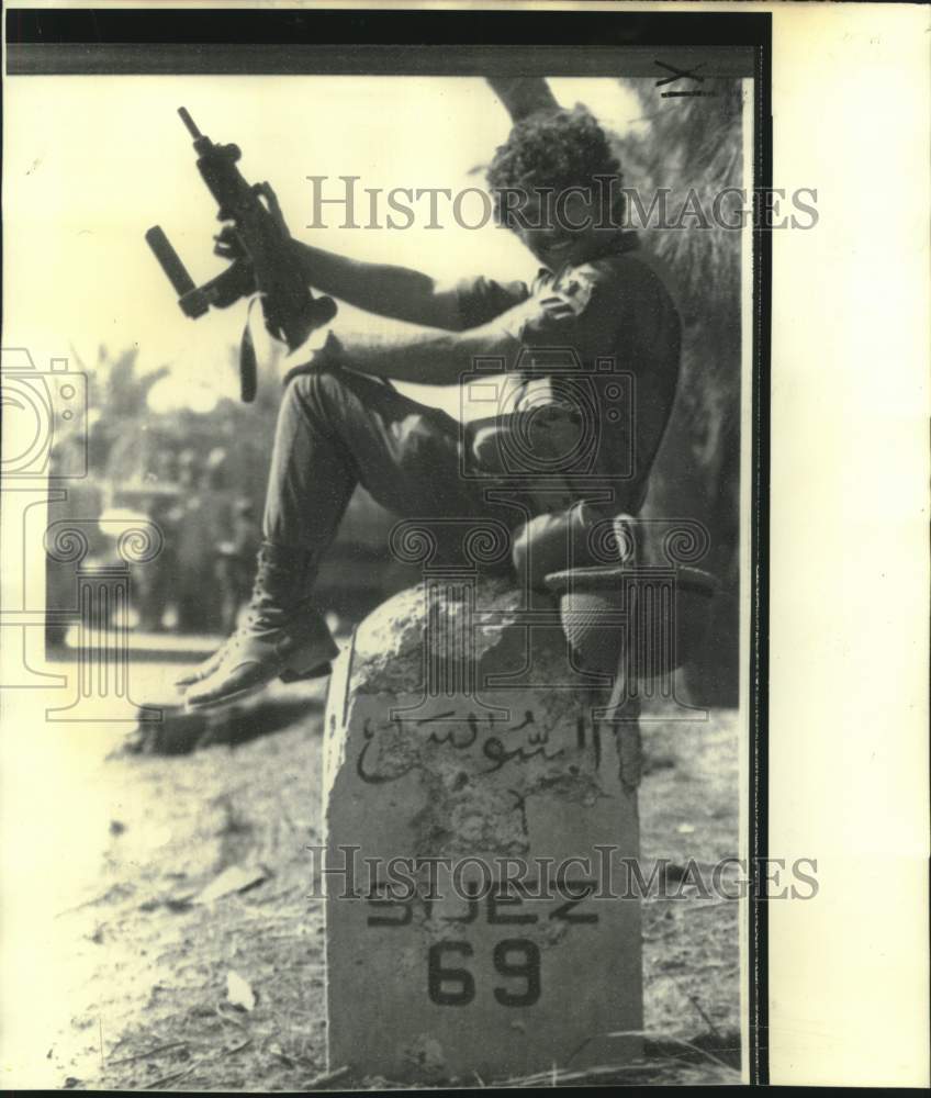 1973 Press Photo Israeli soldier rests on milestone in Sinai Desert - now17299