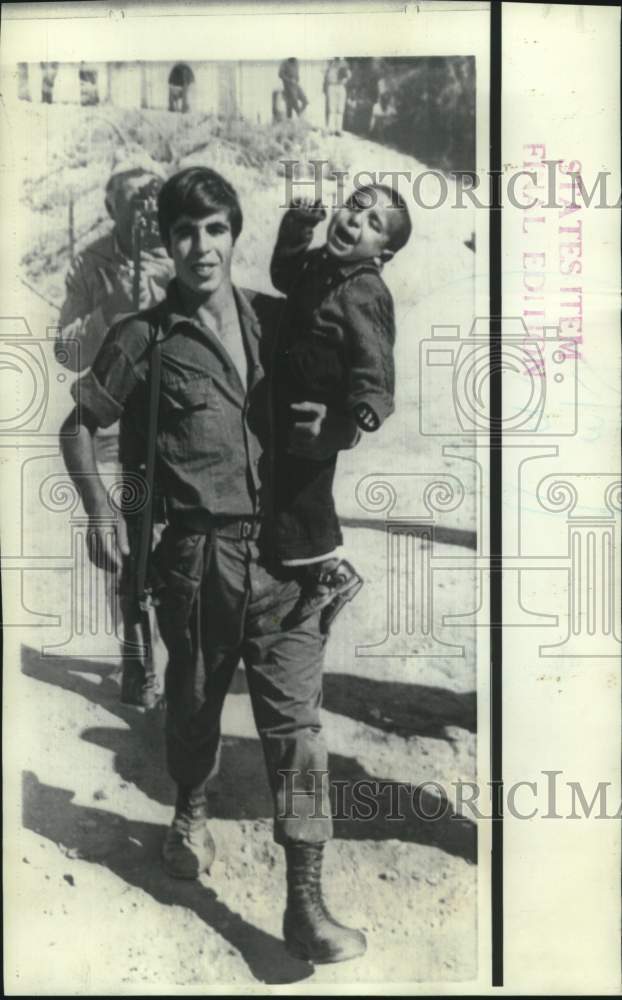 Load image into Gallery viewer, 1969 Press Photo Israeli soldiers carries Arab child to banks of Suez Canal
