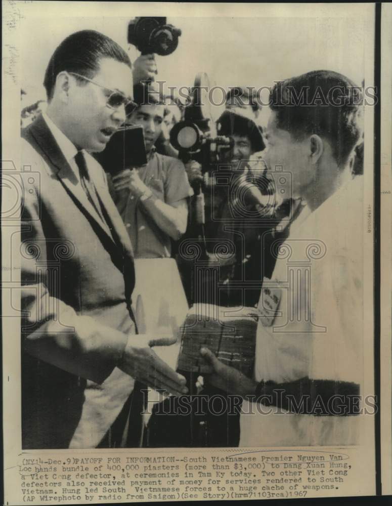 Load image into Gallery viewer, 1967 Press Photo South Vietnam's Premier Nguyen Van Loc hands plasters to Hung
