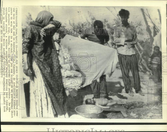 1972 Press Photo Mother mourns and father wraps son in shroud after earthquake