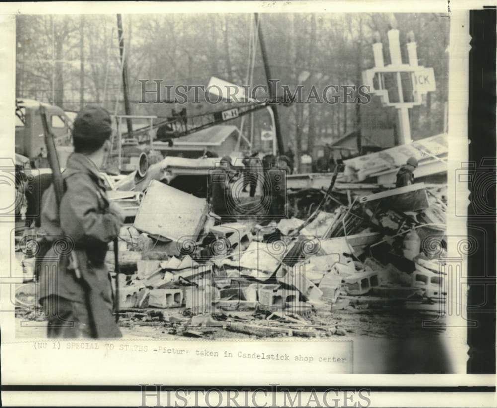 1966 Press Photo Shopping Center rubble searched, armed guardsman on duty.- Historic Images