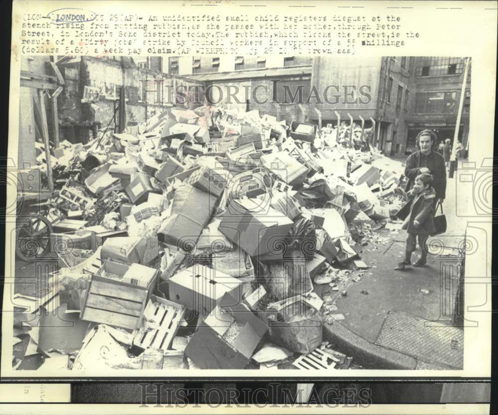 1970 Press Photo Child and mother pass rotting rubbish on London's Peter Street