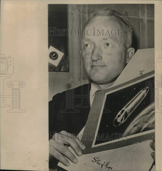 1961 Press Photo John M'Connell holds drawing of peace satellite. - now19175