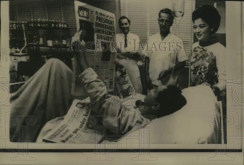 Load image into Gallery viewer, 1967 Press Photo Philippine President Marcos reads newspaper as others watch
