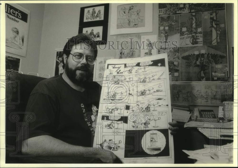 Load image into Gallery viewer, 1993 Press Photo Cartoon historian and critic Rick Marschall, holds cartoon
