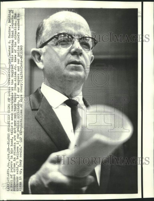 1969 Press Photo Governor Maddox holds roll of newspapers at press conference