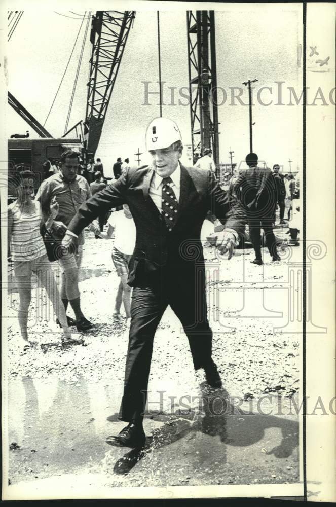 Load image into Gallery viewer, 1971 Press Photo Louisiana Governor McKeithen steps over puddle at stadium
