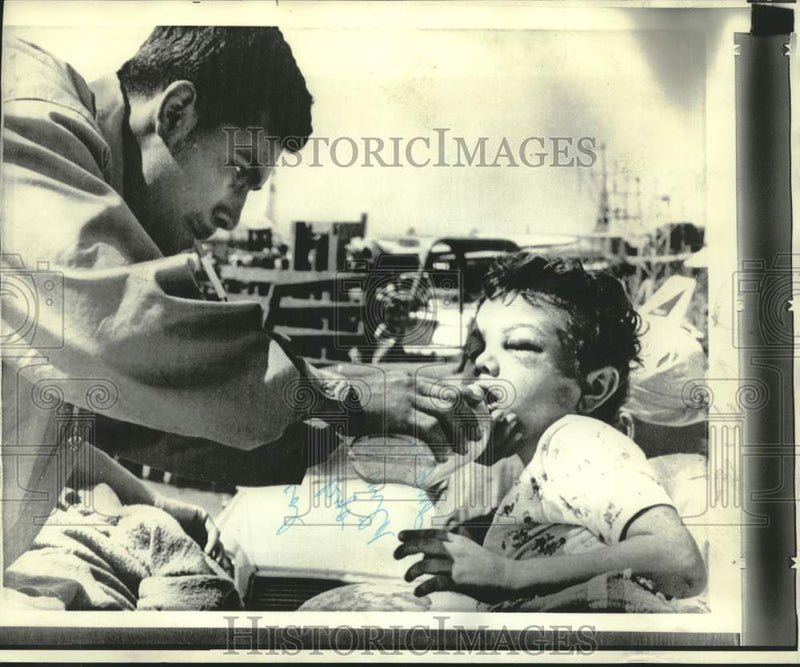 Load image into Gallery viewer, 1972 Press Photo Young Managua boy given water at Managua Airport - now21136
