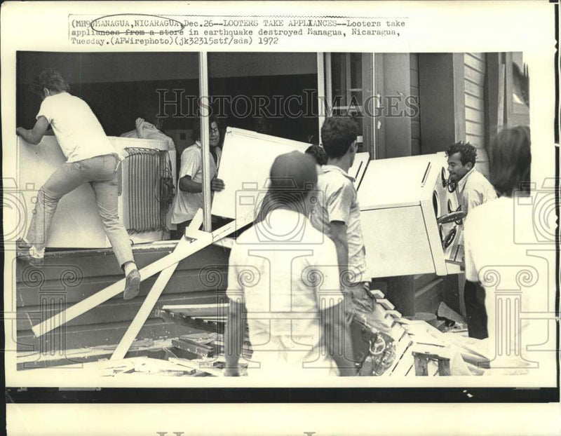Load image into Gallery viewer, 1972 Press Photo Looters take appliances from earthquake destroyed Managua store
