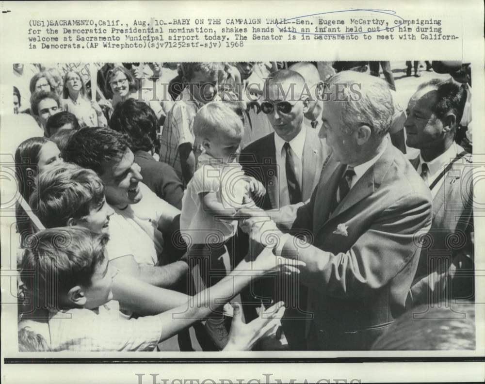 1968 Press Photo Senator Eugene McCarthy shakes babies hand at Sacrament airport