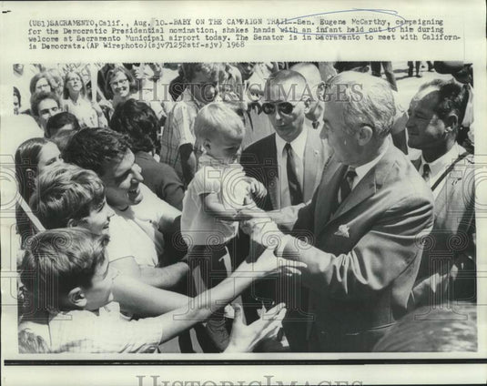 1968 Press Photo Senator Eugene McCarthy shakes babies hand at Sacrament airport