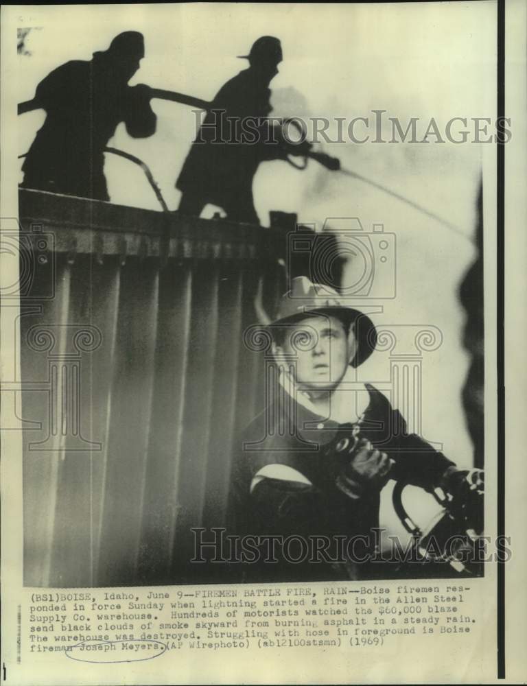 1969 Press Photo Fireman Joseph Meyers and others battle Boise fire and rain