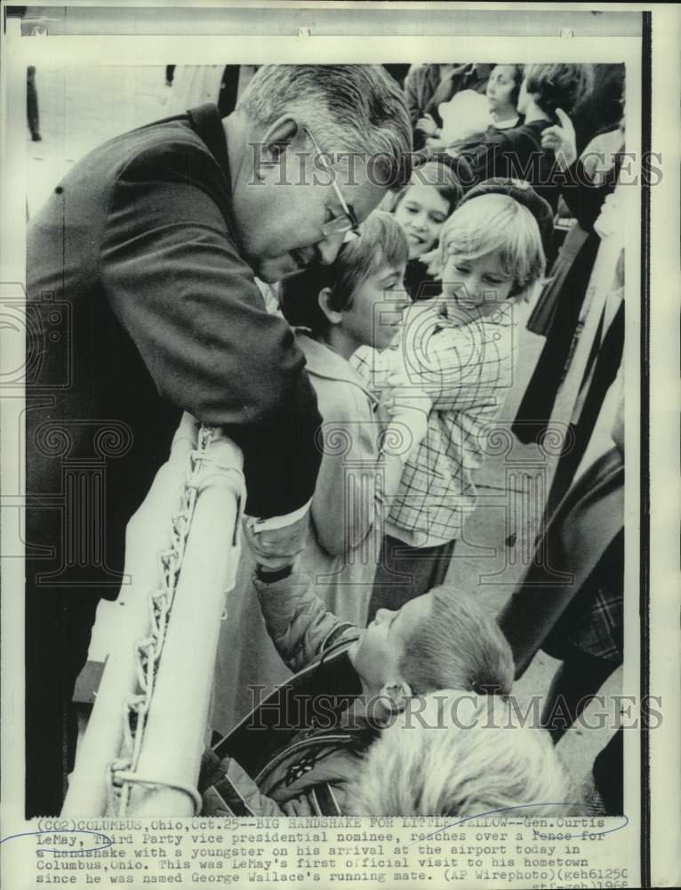 Load image into Gallery viewer, 1968 Press Photo Curtis LeMay reaches over fence for handshake with youngser
