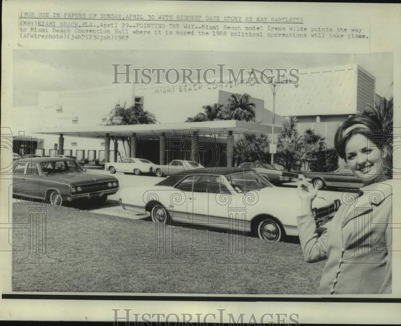 Load image into Gallery viewer, 1967 Press Photo Miami model Irene Wilde points to Miami Beach Convention hall

