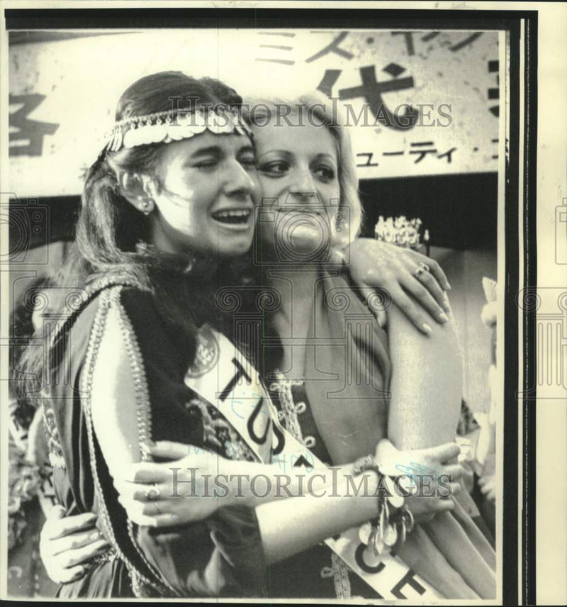 Load image into Gallery viewer, 1974 Press Photo Pageant contestants Deniz Kongu and Panagiataku hug
