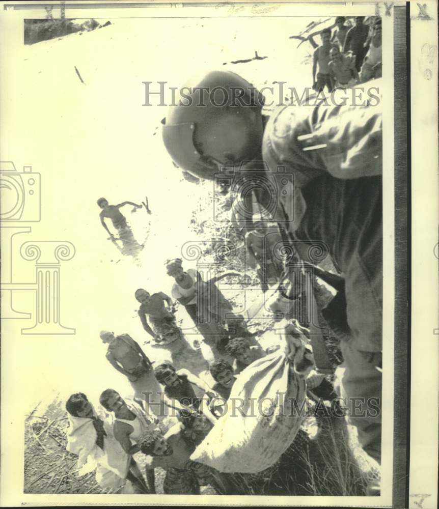 1973 Press Photo U.S. airman leans from relief operations helicopter in Pakistan
