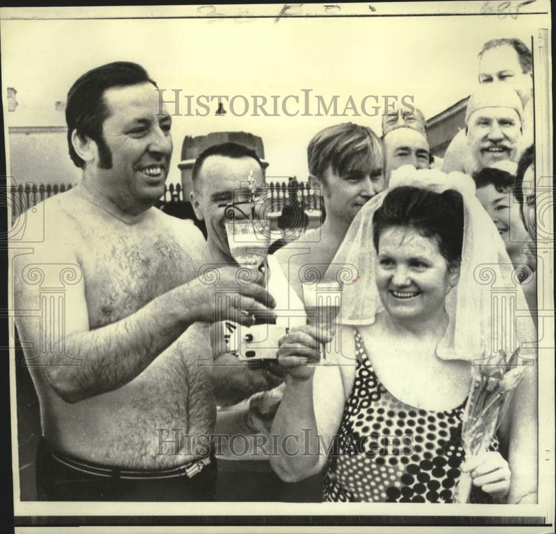 Load image into Gallery viewer, 1973 Press Photo Pyotr and Thaisa Petrov toast before jumping into ice-cold pool
