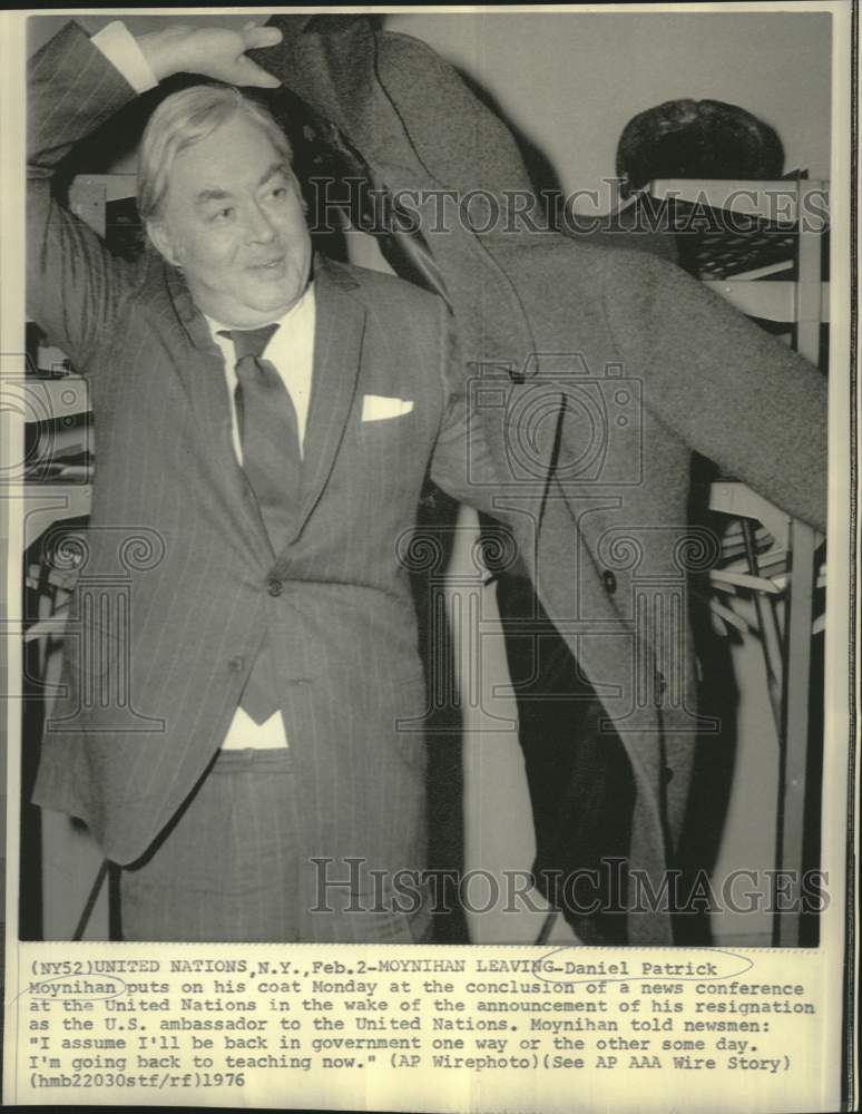Load image into Gallery viewer, 1976 Press Photo Daniel Moynihan puts on coat at end of UN news conference
