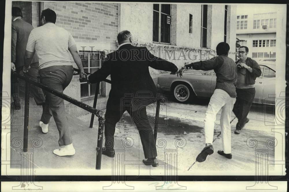 1970 Press Photo Narcotics suspect swings at news photographer in Miami