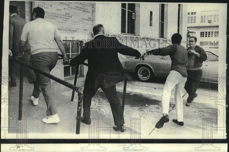Load image into Gallery viewer, 1970 Press Photo Narcotics suspect swings at news photographer in Miami
