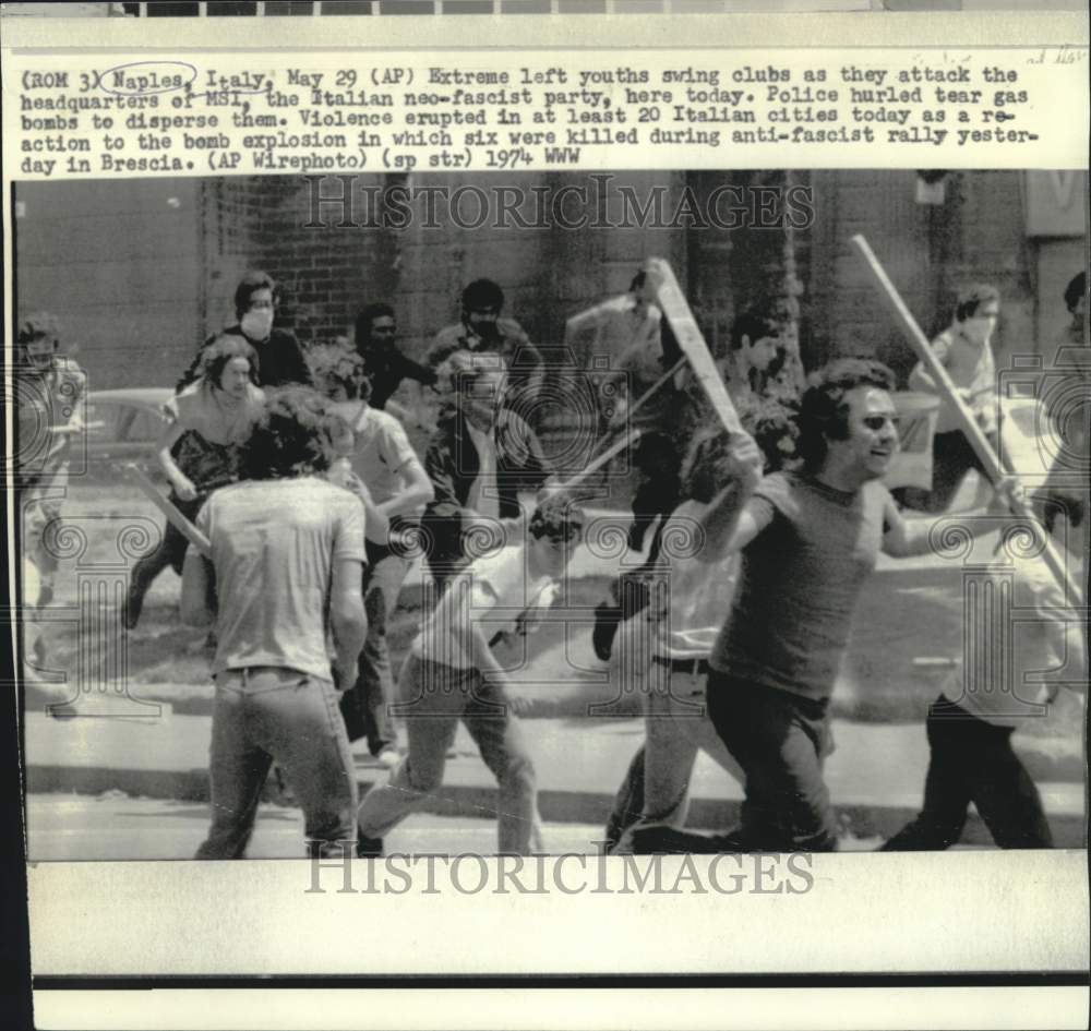 1974 Press Photo Italian youths swing clubs attacking MSI headquarters in Naples