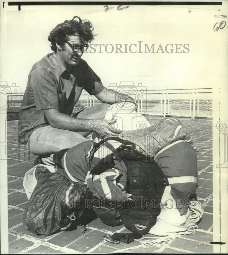 Load image into Gallery viewer, 1970 Press Photo Skydiver Willie Ray looks over life-saving reserve parachute
