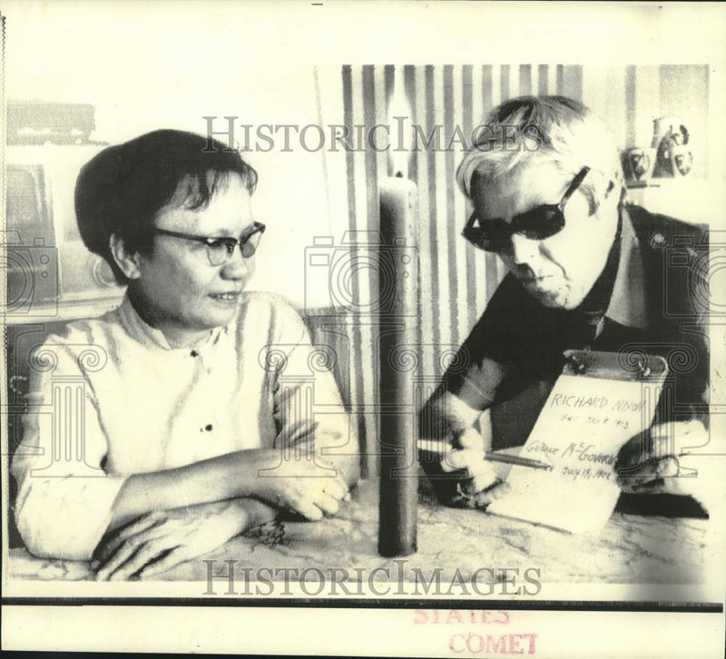 Load image into Gallery viewer, 1972 Press Photo Mme. Sishawath and AP correspondent Hugh Mulligan check dates
