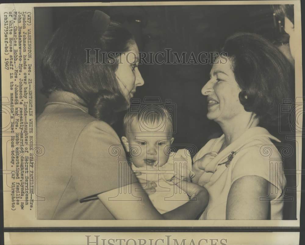 1967 Press Photo Mrs. Lyndon Johnson hands a baby to daughter Lynda Robb, Wash.
