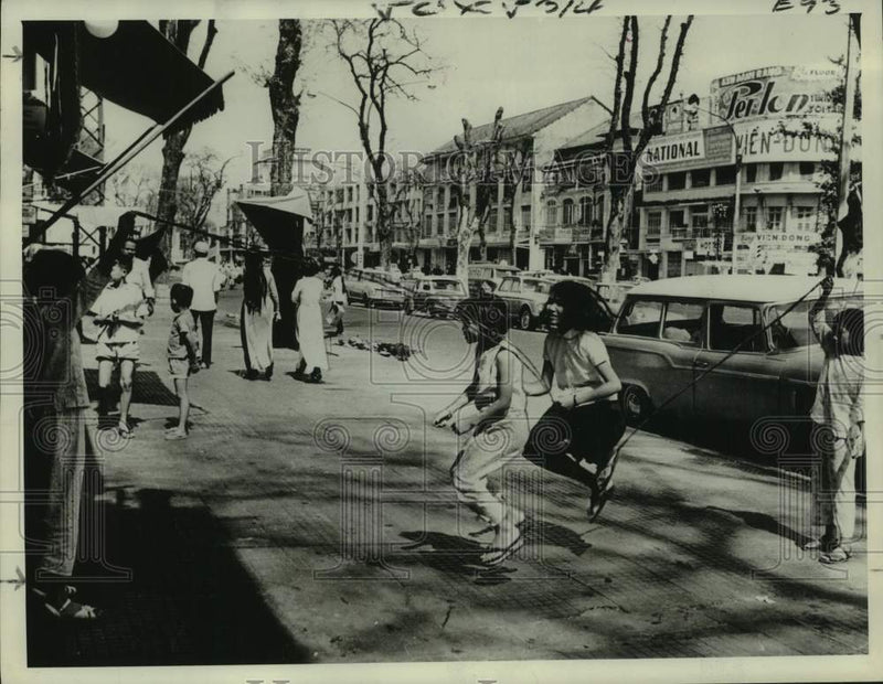 Load image into Gallery viewer, 1969 Press Photo Children play jump rope near the street after the war, Vietnam
