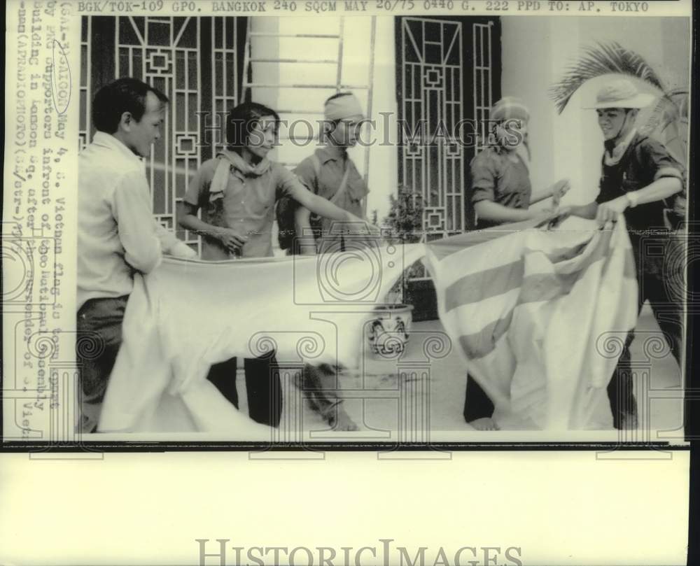 1975 Press Photo North Vietnam Supporters Tear up South Vietnamese Flag, Saigon