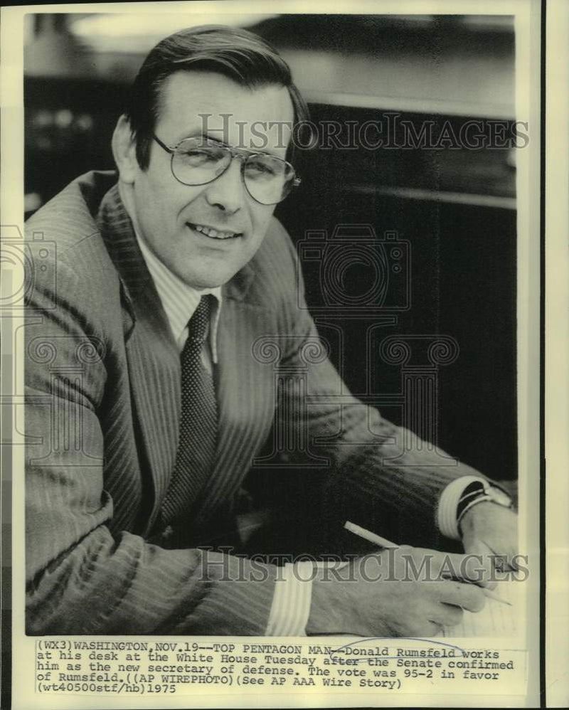 Load image into Gallery viewer, 1975 Press Photo Secretary of Defense Donald Rumsfeld at his White House desk.
