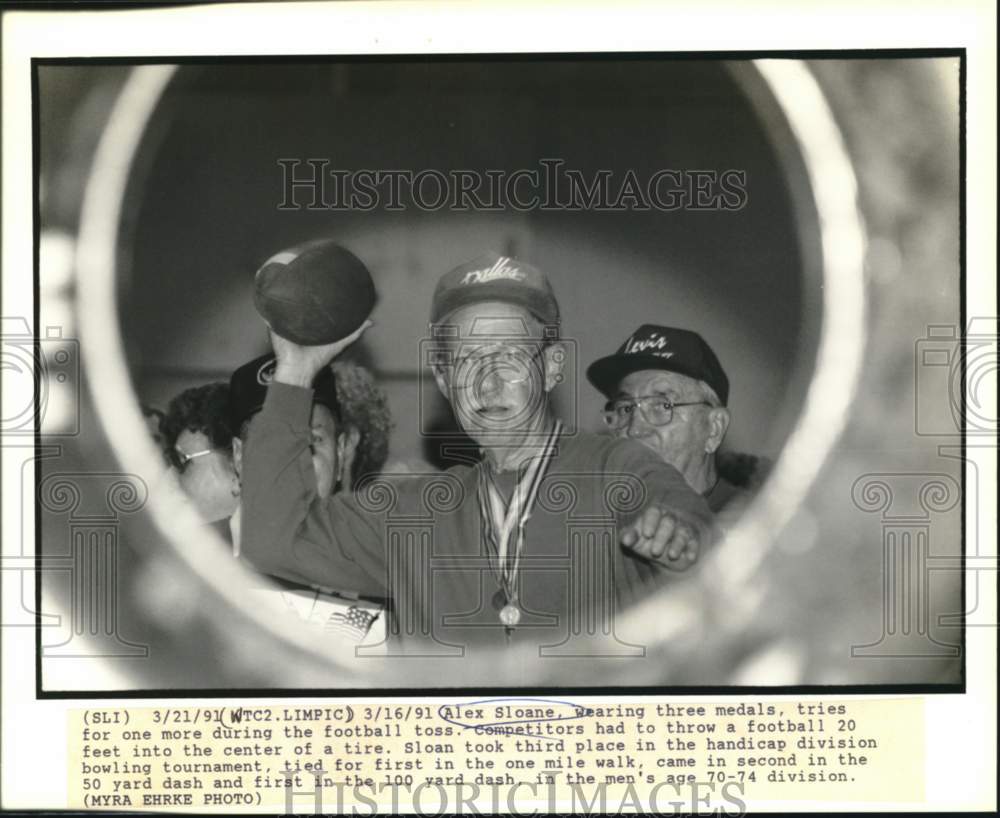 1991 Press Photo Alex Sloane throws football into center of a tire - now51218- Historic Images