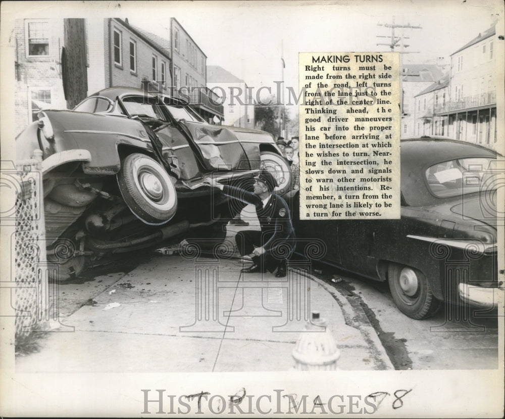 1957 Press Photo Patrolman James Scully inspects damages of car in crash- Historic Images