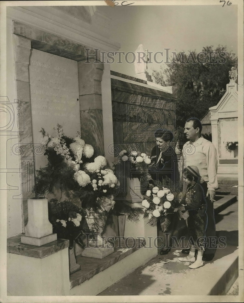 1954 Press Photo Joseph DeLouise and family place flowers on All Saints' Day.