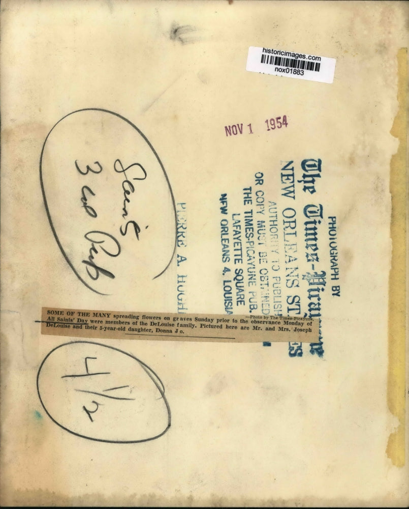 1954 Press Photo Joseph DeLouise and family place flowers on All Saints' Day.