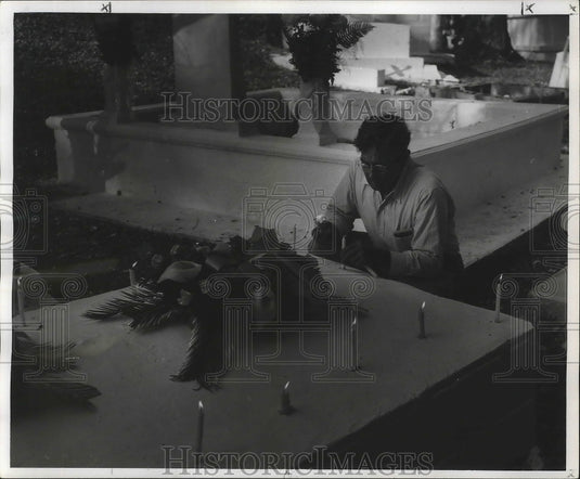 1958 Press Photo Lloyd Adams places candles on grave in Fleming cemetery- Historic Images