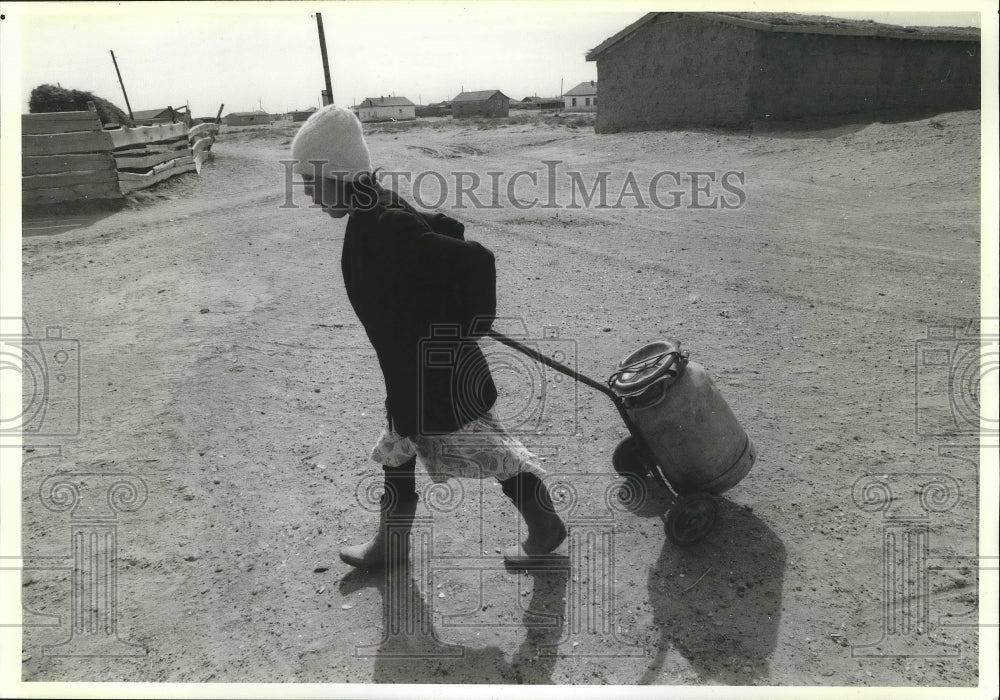 1991 Press Photo A young woman pulls a water cart in Dzhalanadzh, U.S.S.R.