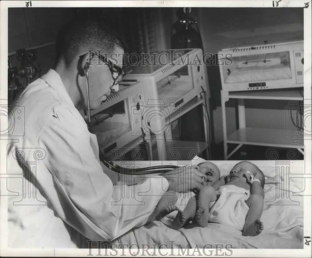 1957 Press Photo Touro resident doctor examines tiny Gill twins after birth.