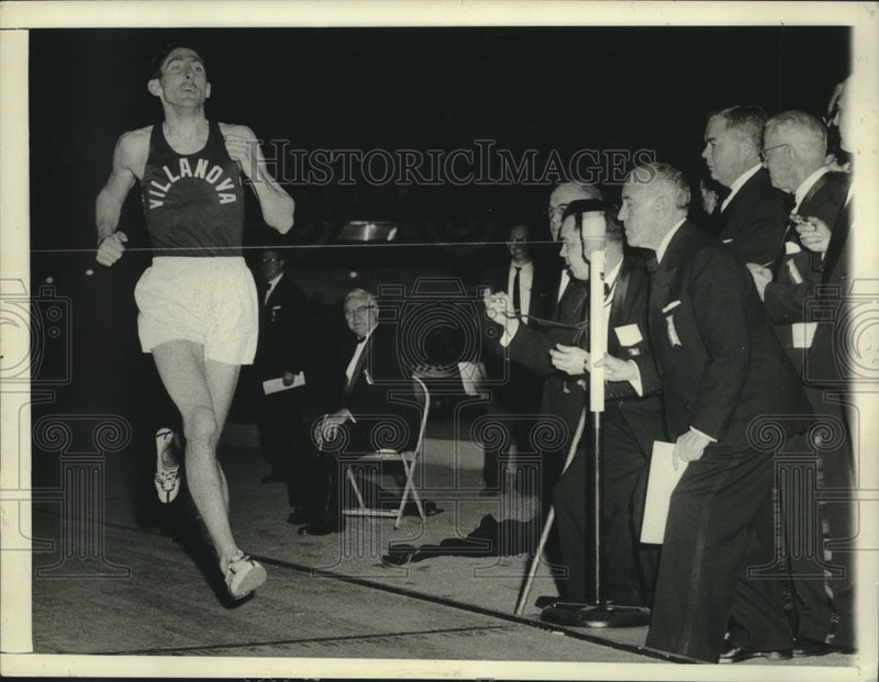 Load image into Gallery viewer, 1958 Press Photo Ron Delany speeds across Finish Line and Officials track Time
