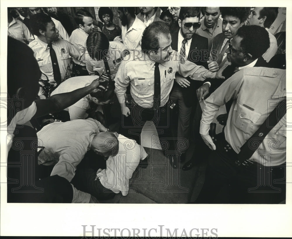 1984 Press Photo Police officers calm a crowd while arresting Pat Bryant